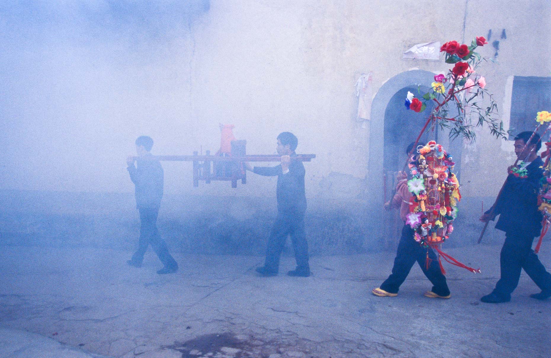 A Buddha being paraded through a Chinese vilage celebration 